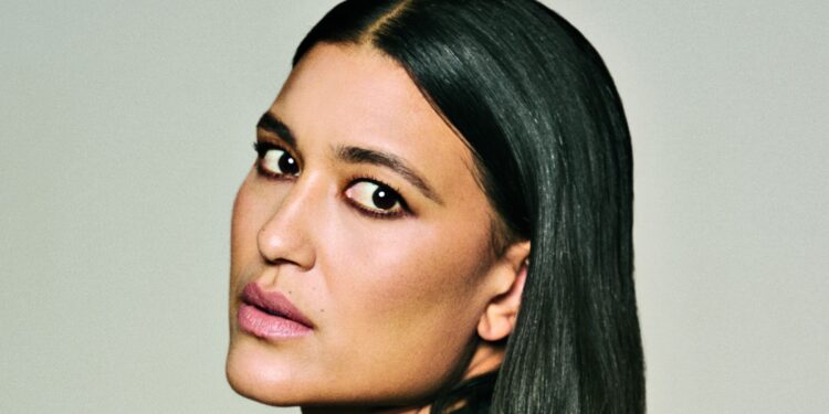 Close-up portrait of Julia Jones with sleek, side-parted black hair, softly smoky eye makeup and muted pink lipstick.